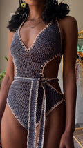 Person wearing a crochet swimsuit with a neutral background